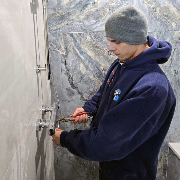 Maximum Plumbing technician installing a new shower faucet near Arlington Heights, IL